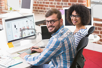 Smiling photo editors using digitizer in office