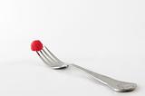 single raspberry on fork