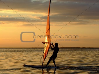 Silhouette of a wind-surfer on waves of a gulf on a sunset 2