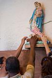 Devotees touching statue of Virgin Mary.