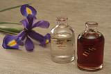 Two bottles with oil and a flower of an iris