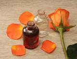 Two bottles with oil and an orange rose