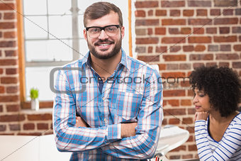 Smiling businessman with arms crossed in office