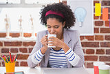 Interior designer drinking coffee at desk