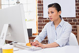 Concentrated woman using computer at desk