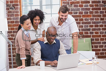 Creative business team using laptop in meeting