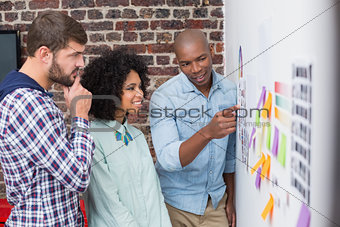 Team looking at sticky notes on wall