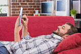Casual man using digital tablet on couch