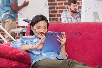 Casual woman using digital tablet on couch