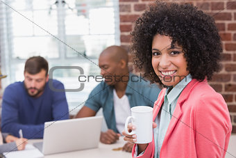Woman with colleagues behind in office