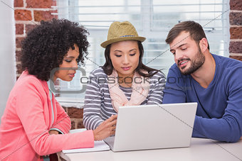 Creative team using laptop in meeting
