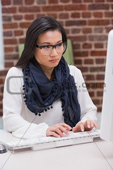 Serious casual young woman using computer