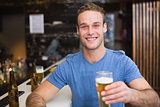Young man holding pint of beer