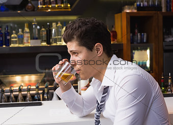 Young man drinking whiskey neat