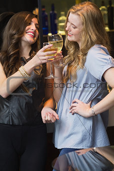 Pretty friends drinking wine together
