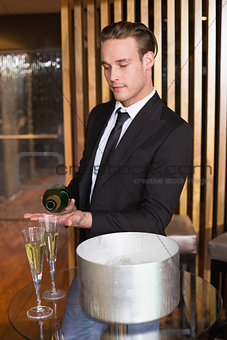 Handsome man pouring glass of champagne