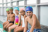 Cute swimming class smiling poolside