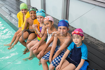 Cute swimming class smiling poolside