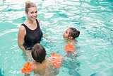 Cute swimming class in pool with coach