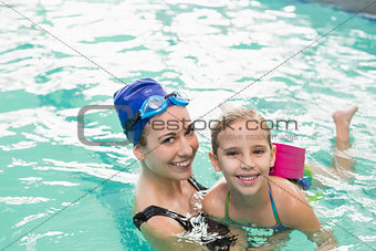Cute little girl learning to swim with coach