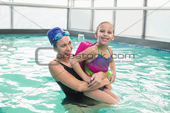 Cute little girl learning to swim with coach