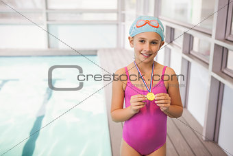 Cute little girl showing her swimming medal