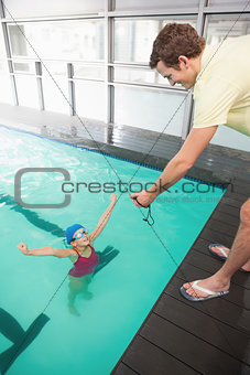 Swimming coach showing time to little girl