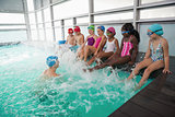 Cute swimming class in pool with coach
