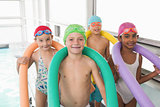 Cute little kids standing poolside with foam rollers