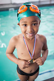 Cute little boy with his medal at the pool