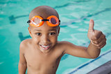 Cute little boy giving thumbs up at the pool