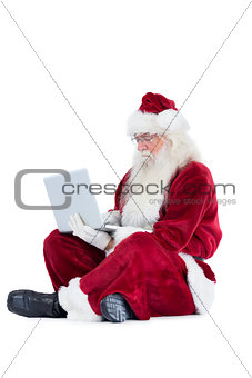 Santa sits and uses a laptop