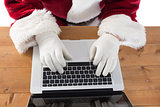 Santa is writing something on his laptop