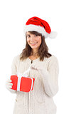 Smiling young woman in santa hat opening a gift