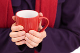Close up of a woman in warm clothing holding mug