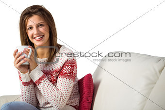 Pretty brunette enjoying a hot drink on the couch
