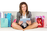 Beautiful woman on sofa with a tablet and credit card