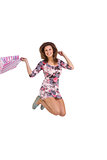 Brunette jumping while holding shopping bags