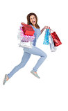 Excited brunette jumping while holding shopping bags