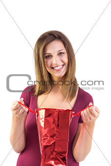 Festive brunette opening a gift bag