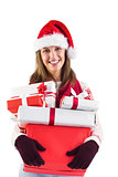 Festive brunette with santa hat holding many gifts