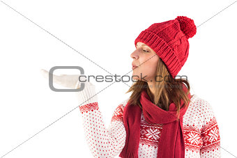 Pretty brunette in winter fashion blowing over hands