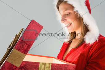 Pretty santa girl opening a gift
