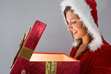 Pretty santa girl opening a gift