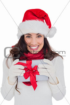 Festive brunette in santa hat holding gift
