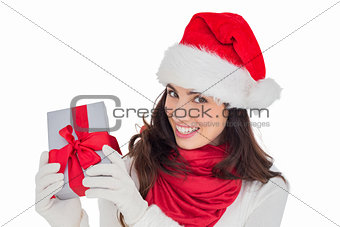 Excited brunette in santa hat showing gift