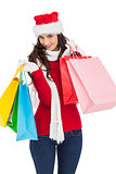 Smiling brunette in winter wear holding shopping bags
