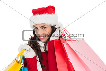 Festive brunette in winter wear holding shopping bags