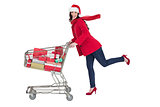 Festive brunette pushing trolley full of gifts