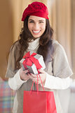 Happy brunette holding gift and shopping bags